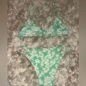 White floral on a light minty green background. Fits size xs.